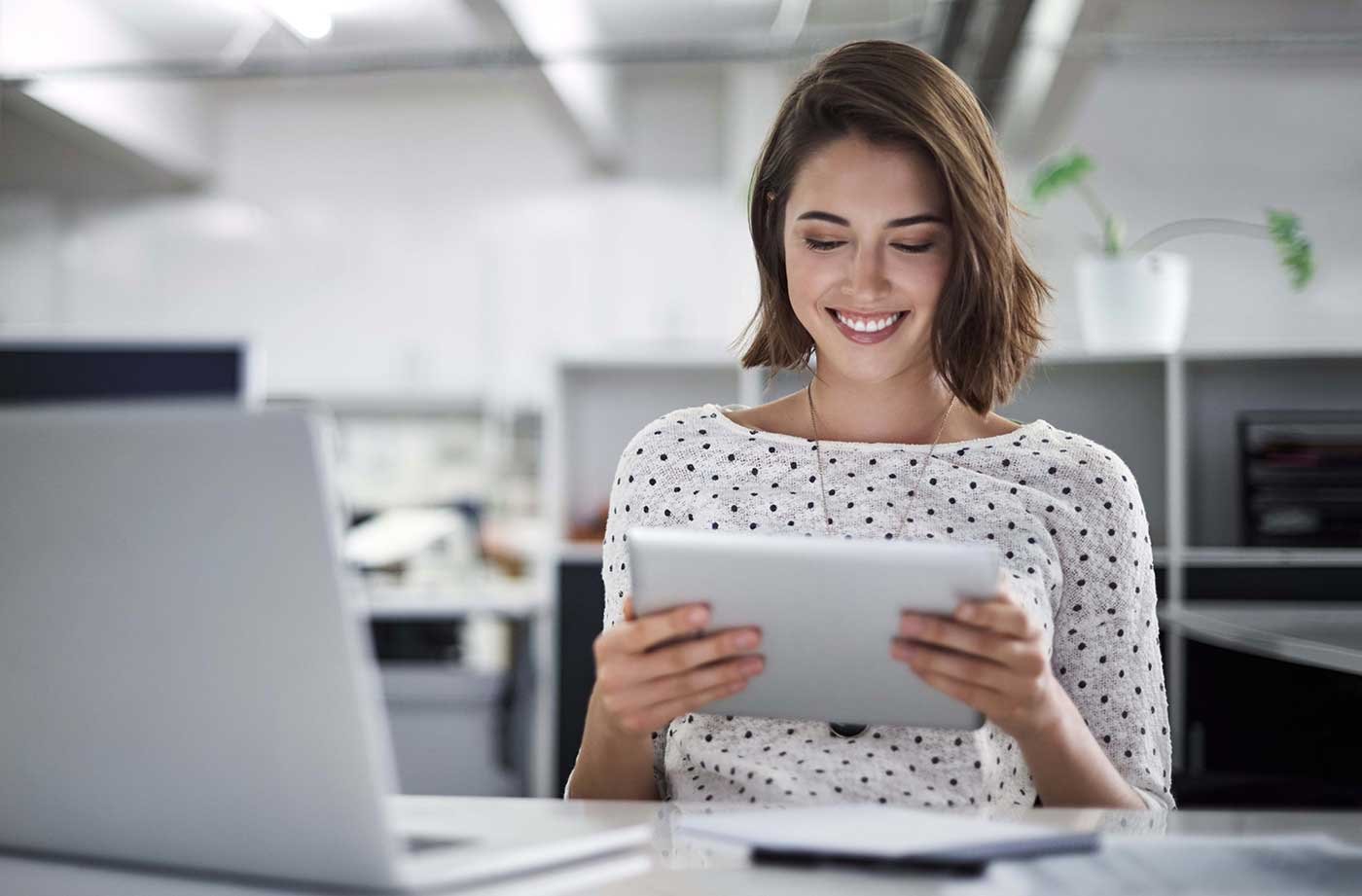 Woman reading a tablet at her desk