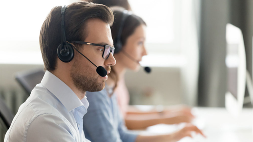 Confident-call-center-operator-agent-in-headset-consulting-client-online